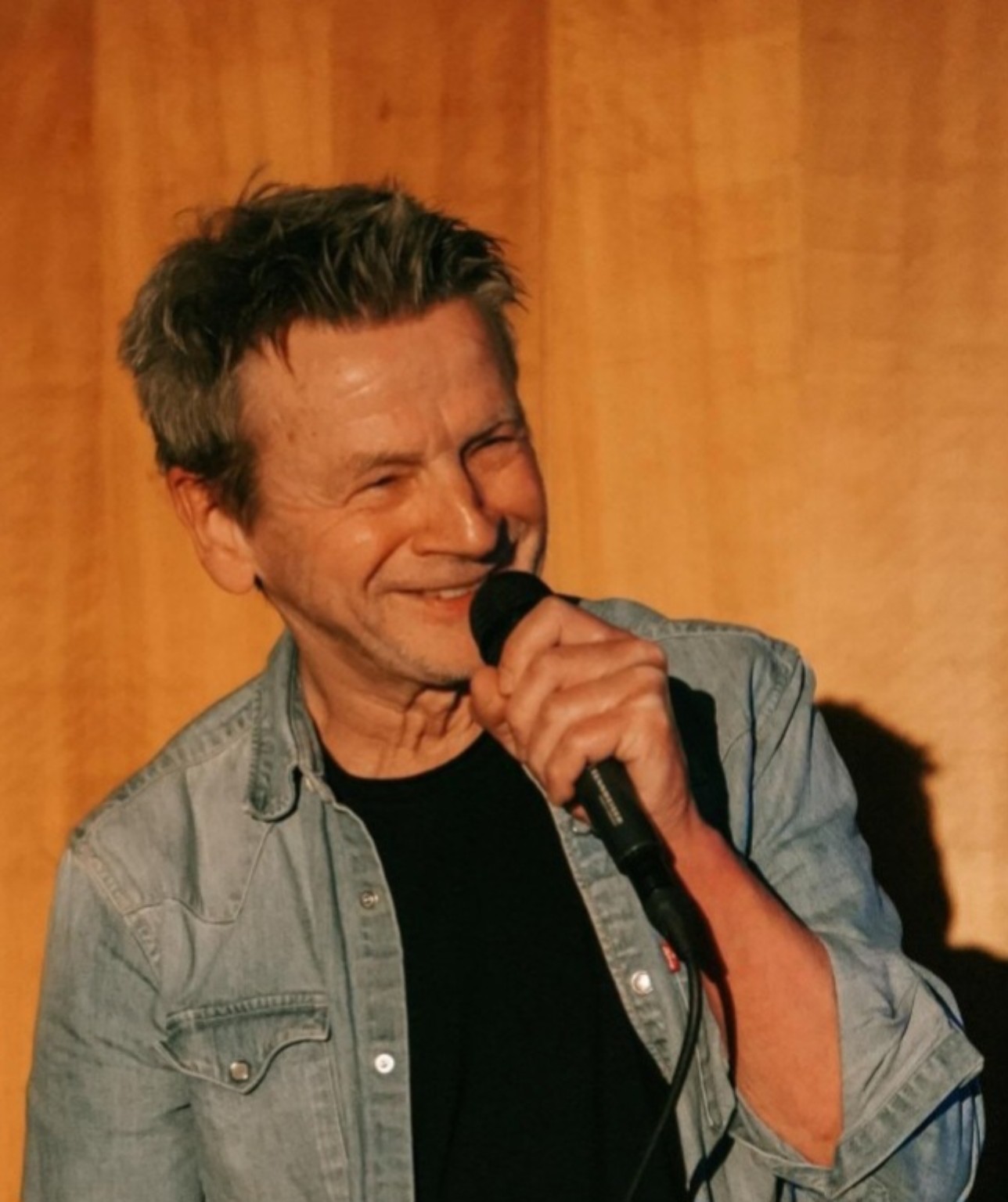 Jürgen Happe mit Mikrofon auf der Bühne