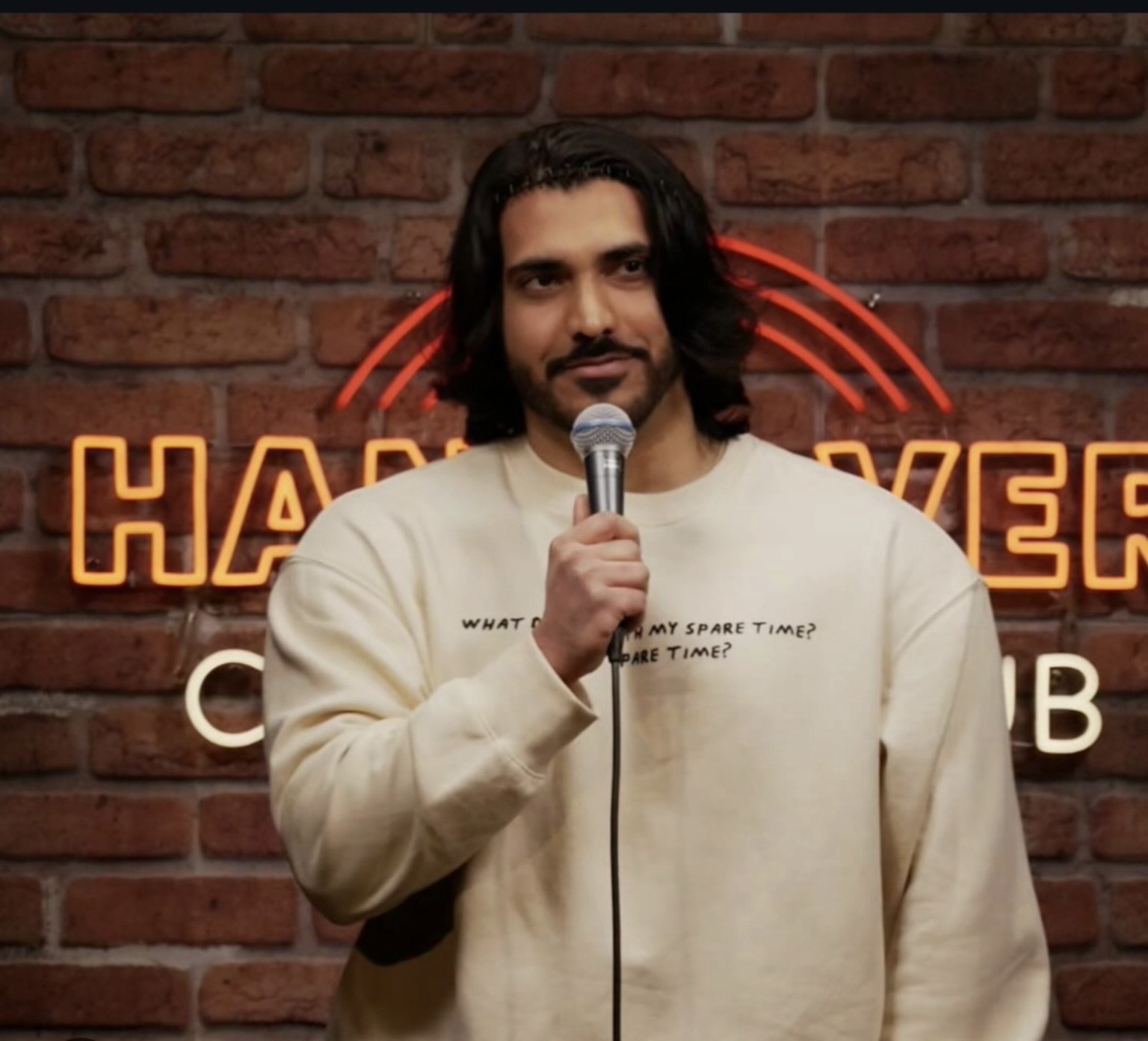 Omar mit Mikrofon auf der Comedy-Bühne